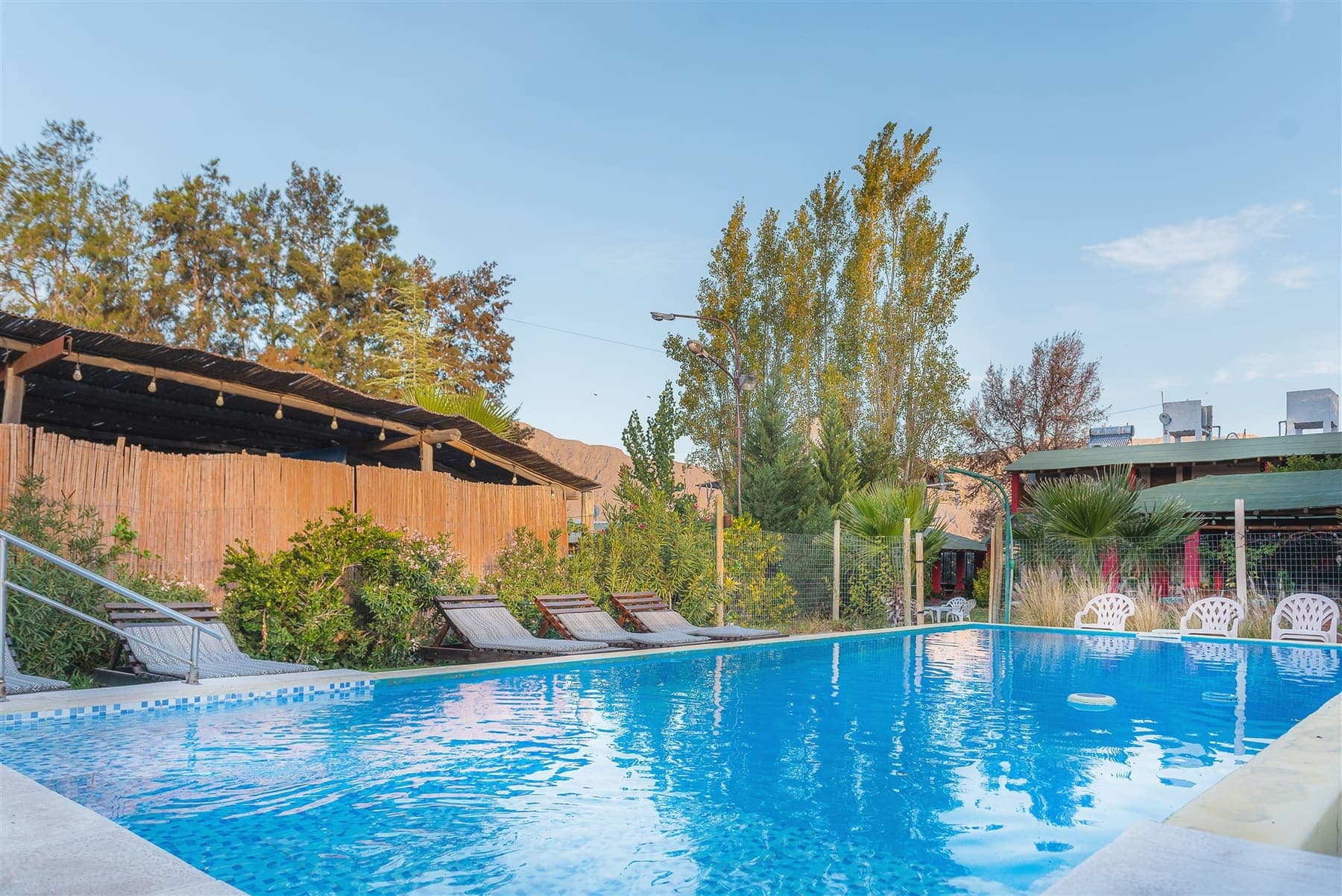 Pileta con reposeras, jardines y montañas en La Posada del Ángel